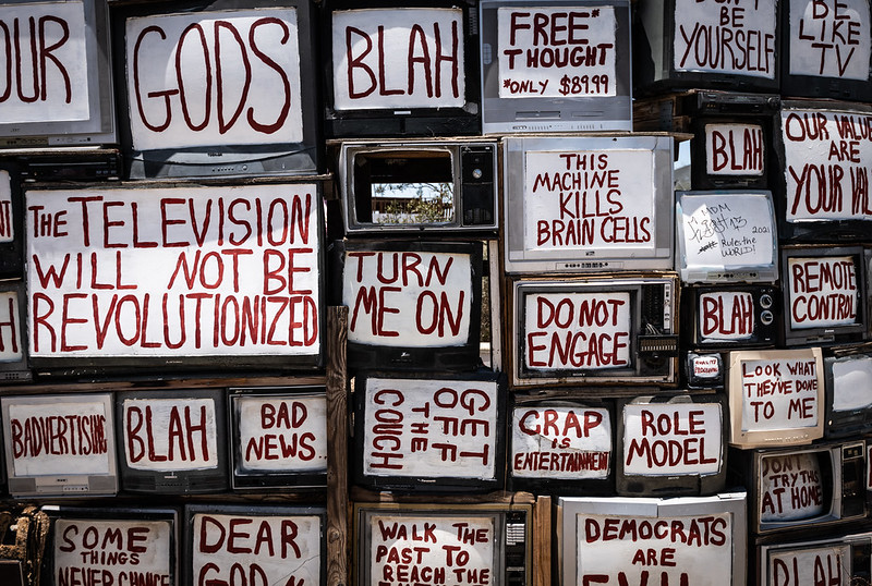 TVs stacked as wall and painted over with anti-television messages